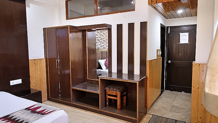 A view of the wardrobe and dressing mirror set up in a room at DLS Hotel Devlok, Manali