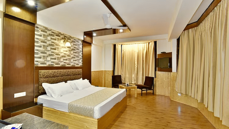 A room at DLS Hotel Devlok, Manali with a double bed, a coffee table set up and wooden flooring