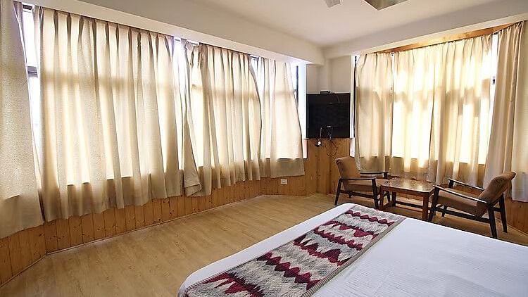 A room at DLS Hotel Devlok, Manali with a double bed and a television attached to a corner