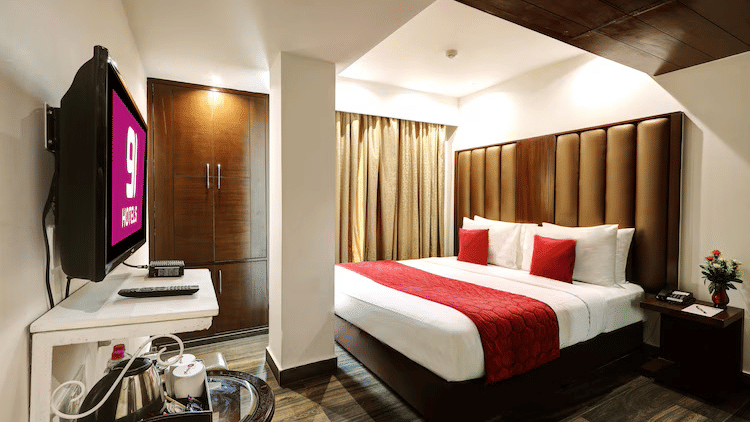A well-organised double room with a warm wooden ceiling detail, integrated storage, and a television facing the bed - Flute Boutique By Hotel 91, Jaipur