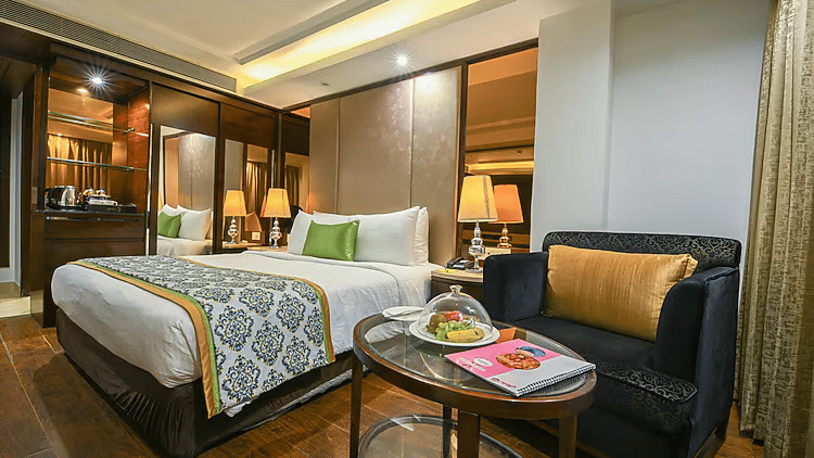 A wide-angle view of an executive room including a dedicated seating area with a velvet sofa and a bedside workspace - Flute Boutique By Hotel 91, Jaipur
