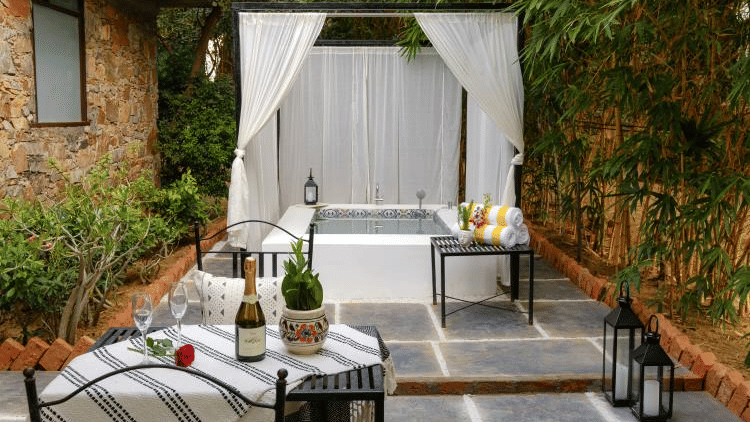 Poolside dining tables and chairs at Valley by Grassfield, a resort in Jaipur.