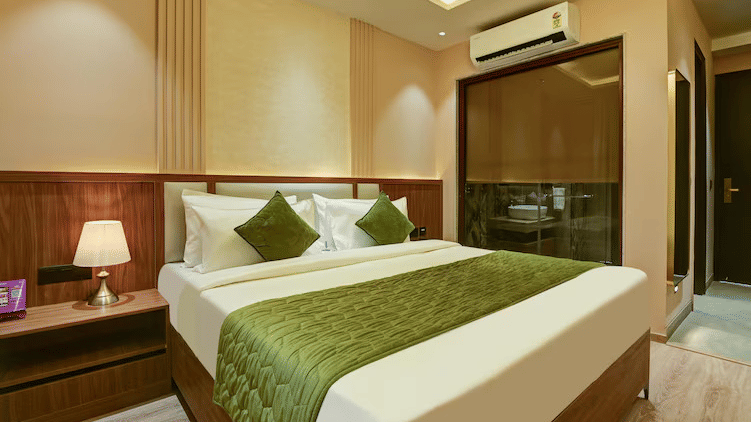Corner view of the double bed with a bed-side table lamp brightly lit at the Executive Room of Hotel 91 Privé, Gurugram.