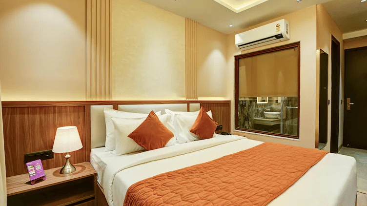 Corner view of the Standard Room at Hotel 91 Privé, Gurugram, featuring a plush double bed along with a split air-conditioning in the room.