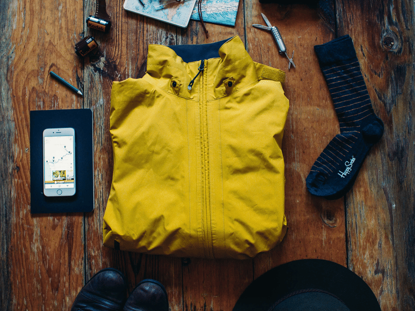 A top angle shot featuring a yellow zip jacket along with a pair of socks, footwear, and a hat.