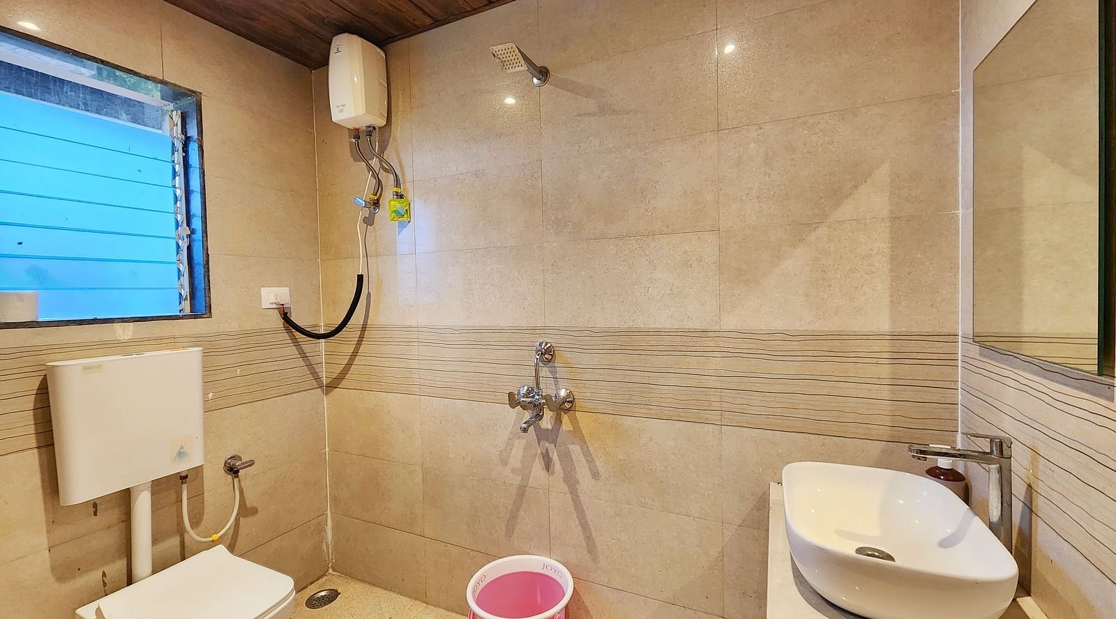 Bathroom of Pool View Standard Room at The Kanila Resort featuring a toilet, sink area and a bucket.