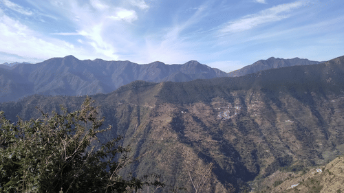an overview of the Garhwal hills in Uttarakhand with blue sky in the background