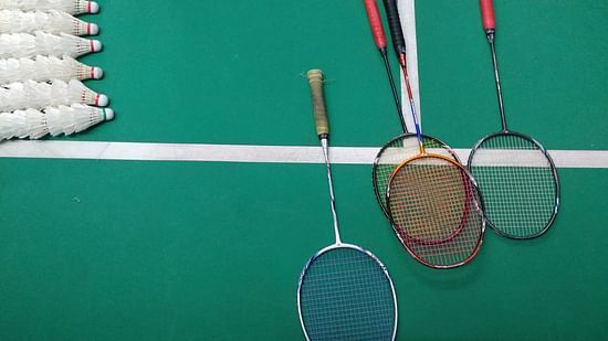 green and white court with badminton rackets