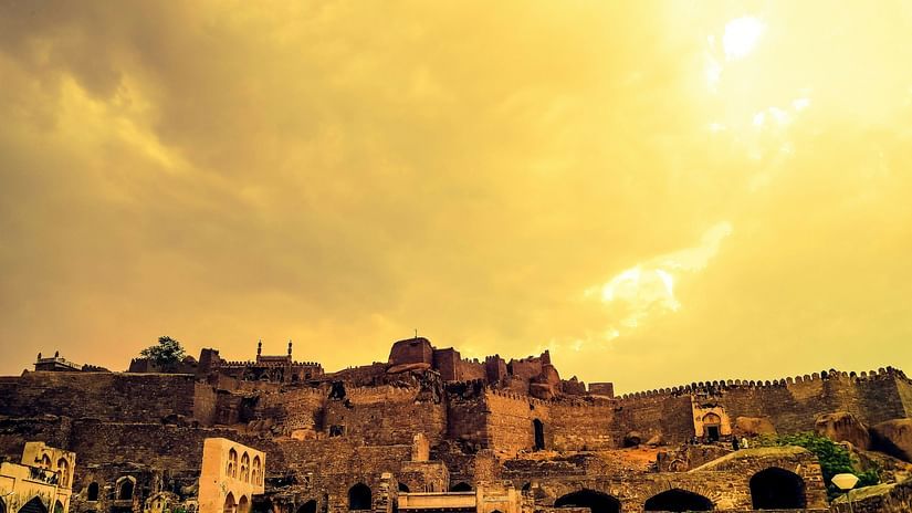 an image of golconda fort with yellow sky background 