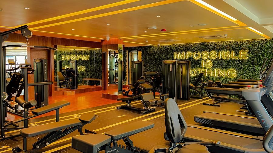 Fitness Center at KertelSuites, featuring modern gym equipment and the motivational quote Impossible is Nothing displayed