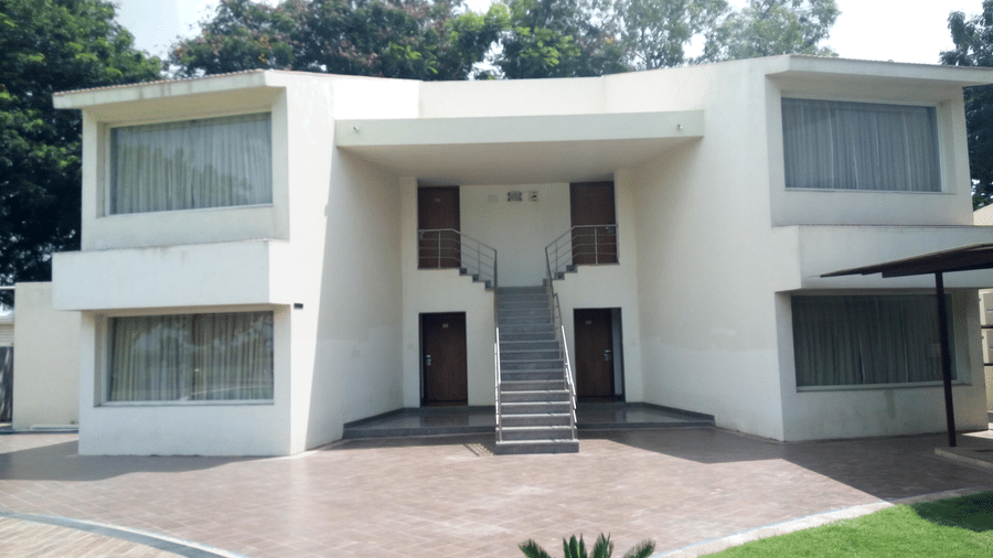 a cottage room entrance with a lawn area in front at Top3 Lords Resort Bhavnagar