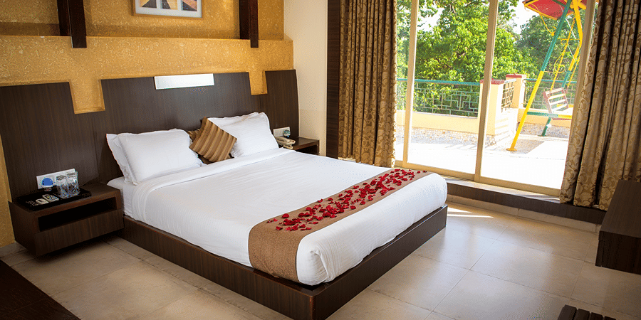 A view of the bed beside the window in Royal suite bedroom with glass doors leading to the terrace.