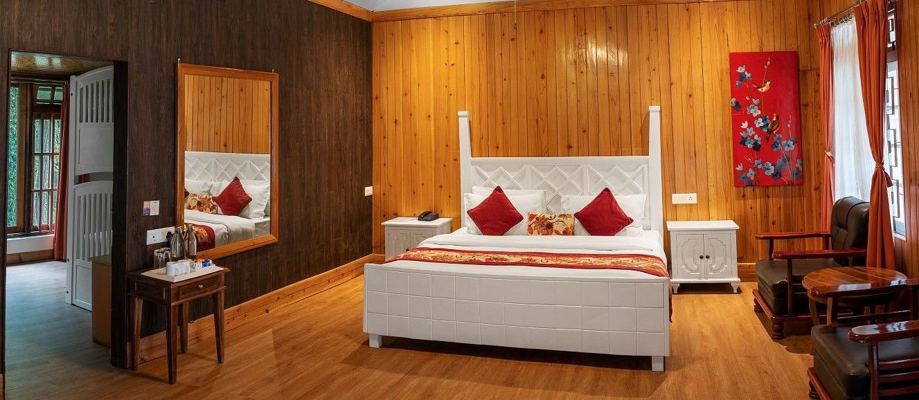 A room at Summit Barsana Resort & Spa, Kalimpong with a double bed and large windows
