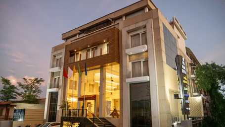 The exterior of Mansha Hotel Regency, a multi-storey building with a modern design, captured during early evening | Mansha Hotels