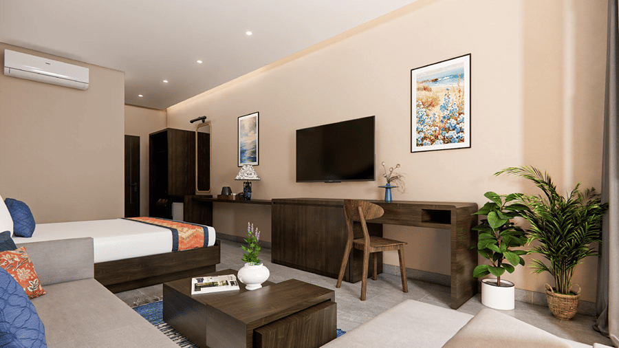 Modern suite interior with a cozy lounge sofa, coffee table, desk station, flat-screen television, and green potted plant.