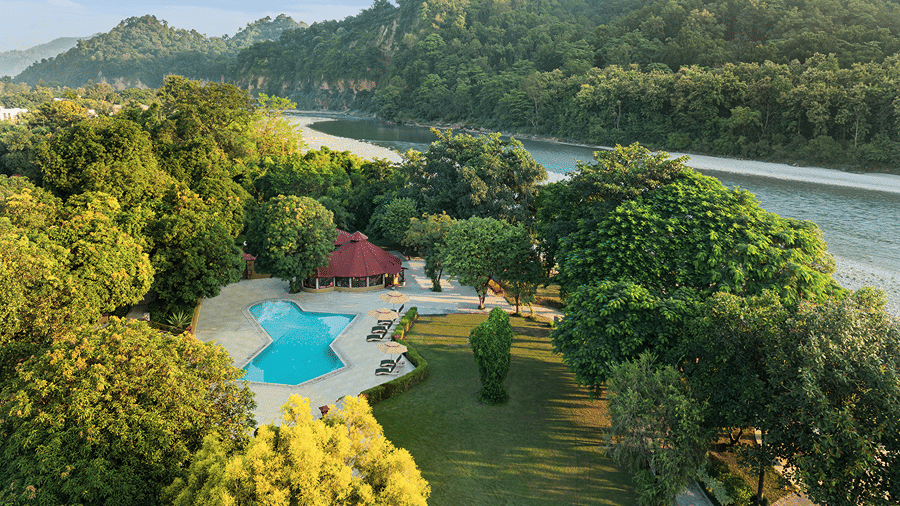 Aerial view of the resort swimming pool, surrounding gardens and river landscape at The Riverview Retreat, Corbett.