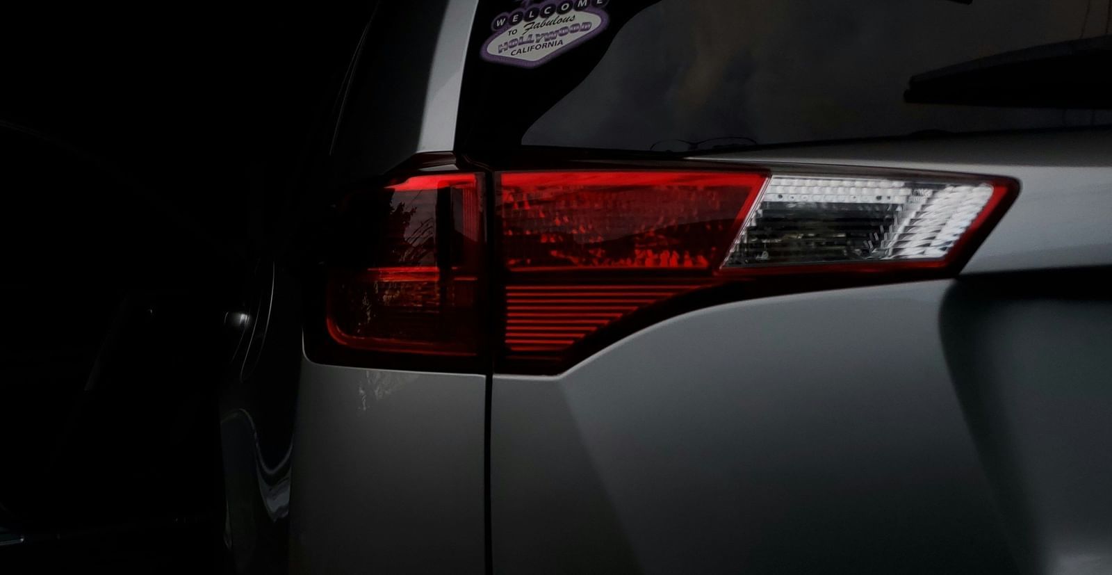 Rear view of cars parked in the dark.
