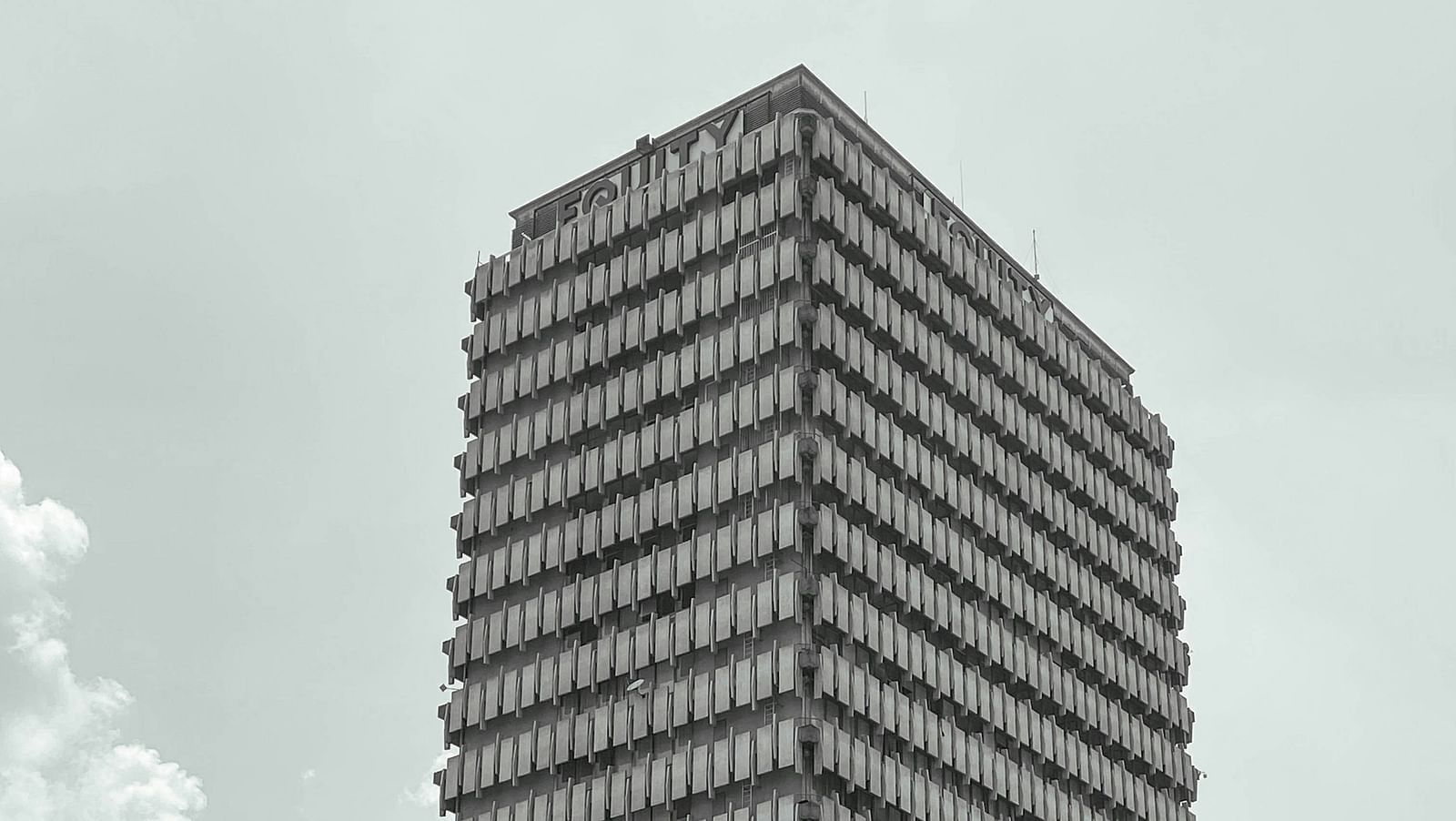 A far out view of an office building in Kimshasa with clear sky in the background.