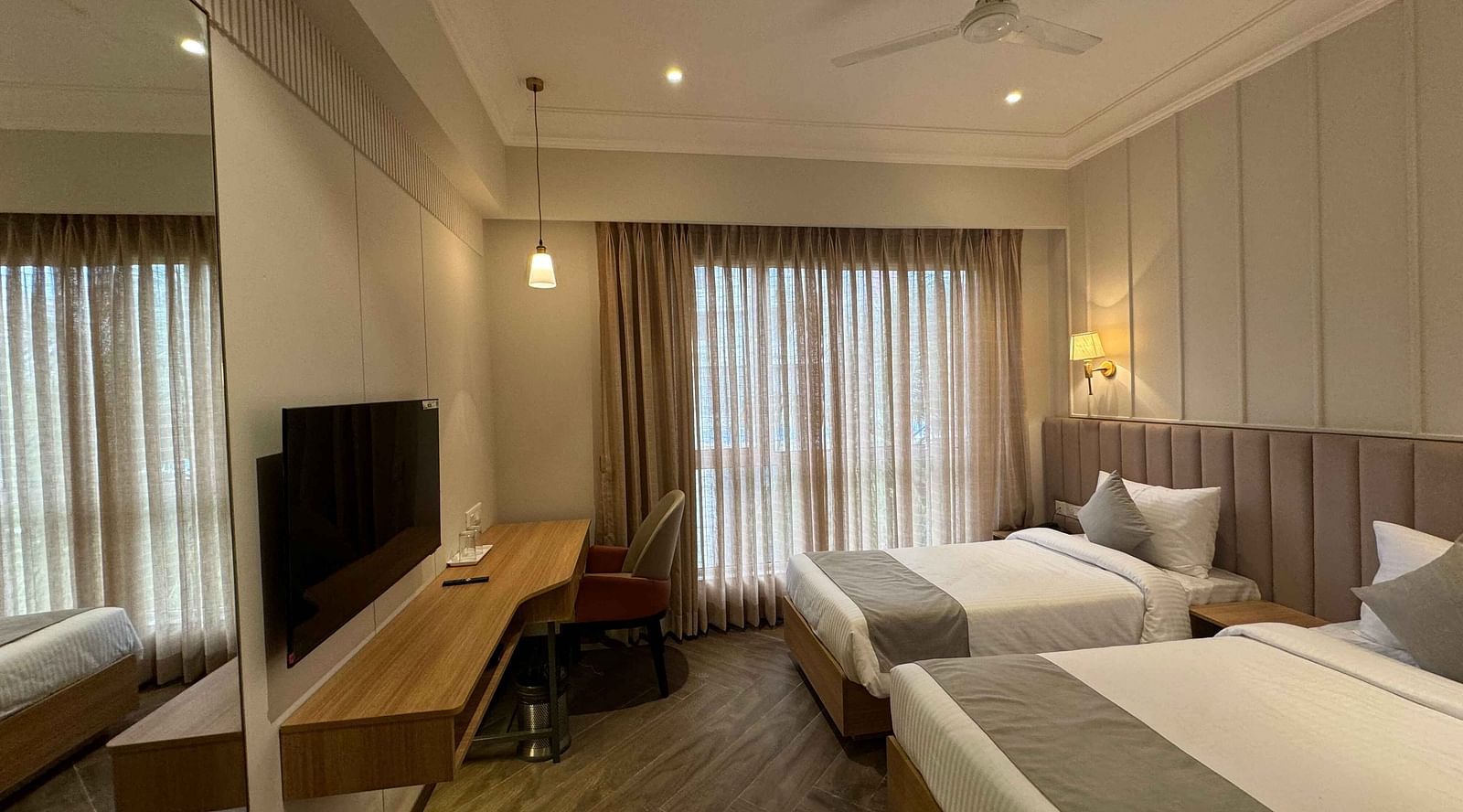 side view of the twin bedroom with a television at  Hotel Mumbai House Mindspace Malad