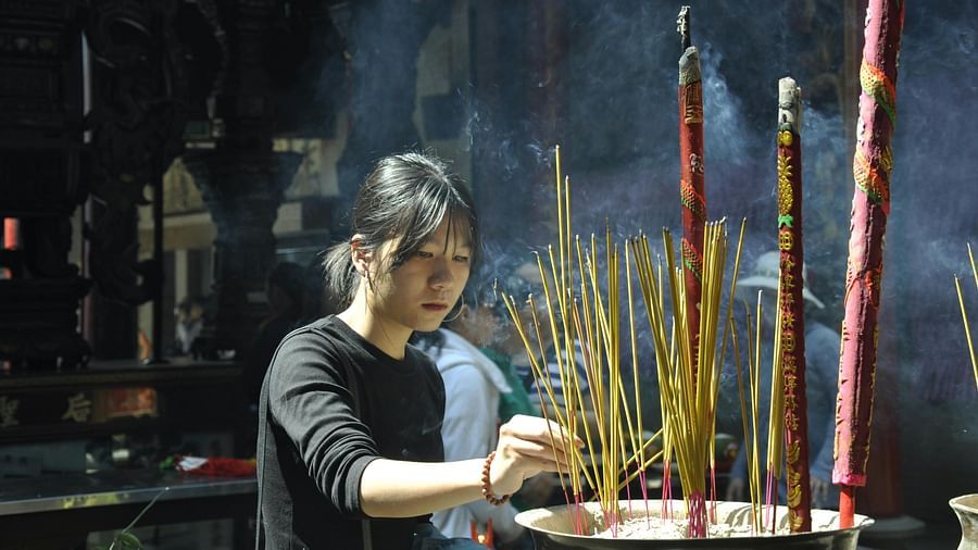a shot of  a girl offering prayers at temples in prayagraj