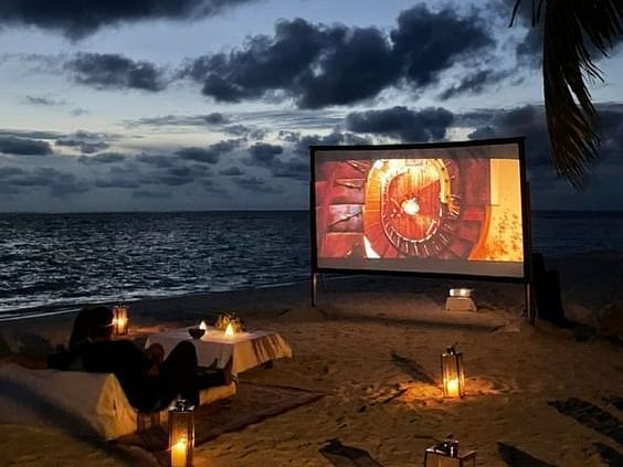 movie by the beach, screen, candles, sand, soothing sea waves.