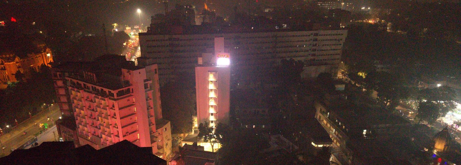 An aerial view of a city at night, illuminated by numerous lights from buildings and streets | Pravasa Vadodara
