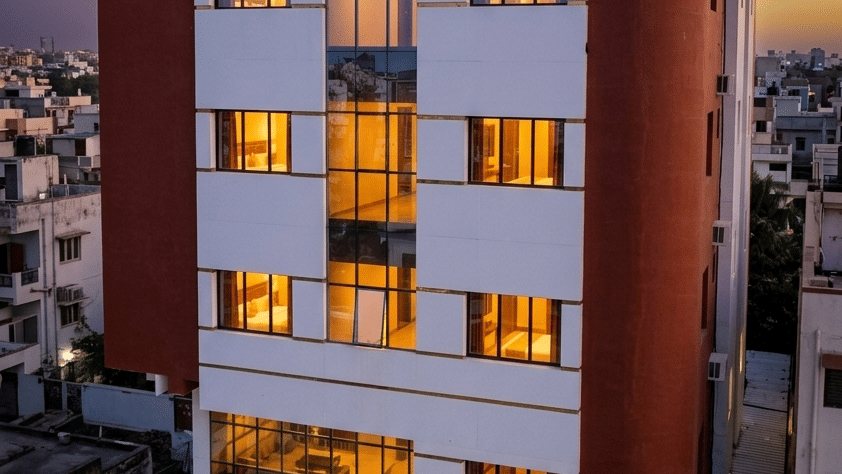 Exterior view of Vaikunth by Adamo  hotel  with glowing windows captured during twilight.