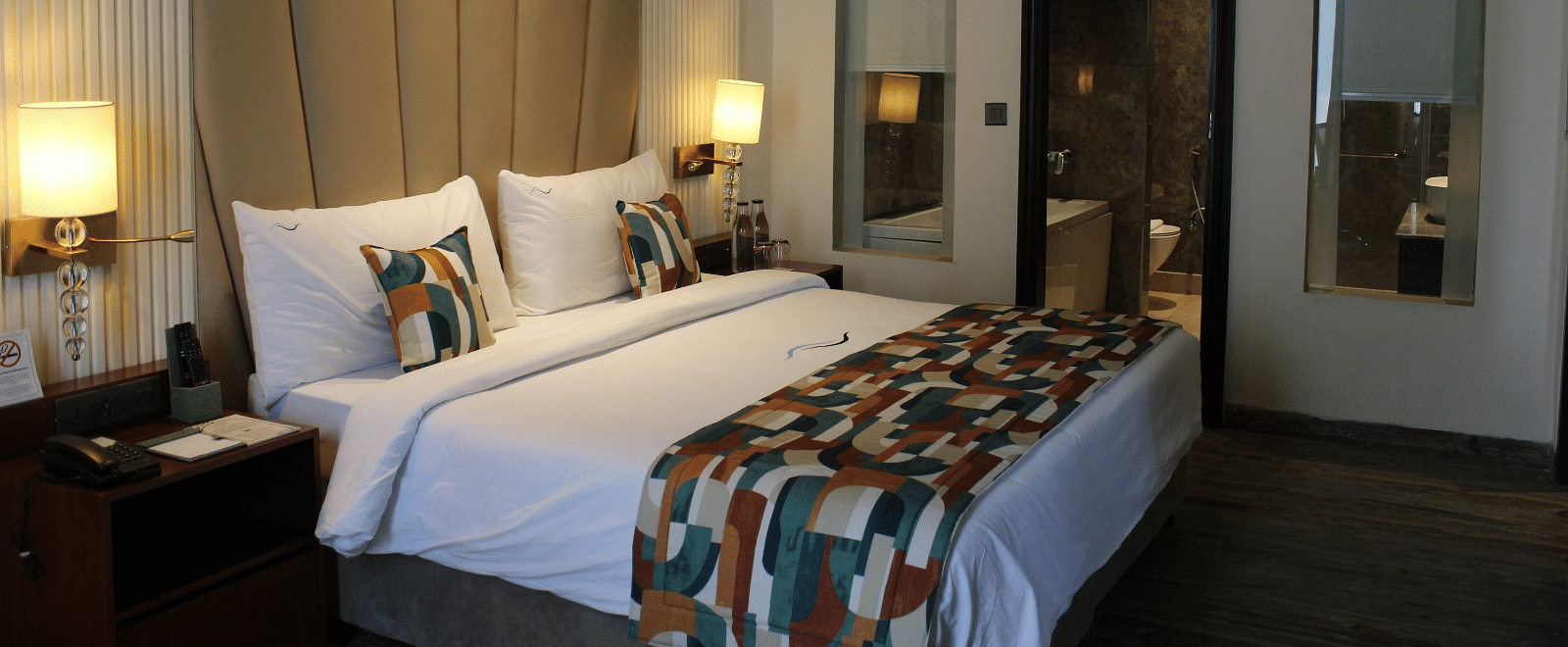 Side view of a bedroom featuring two lamps next to each other on either side of the bed at BluSalzz Residence, Amritsar