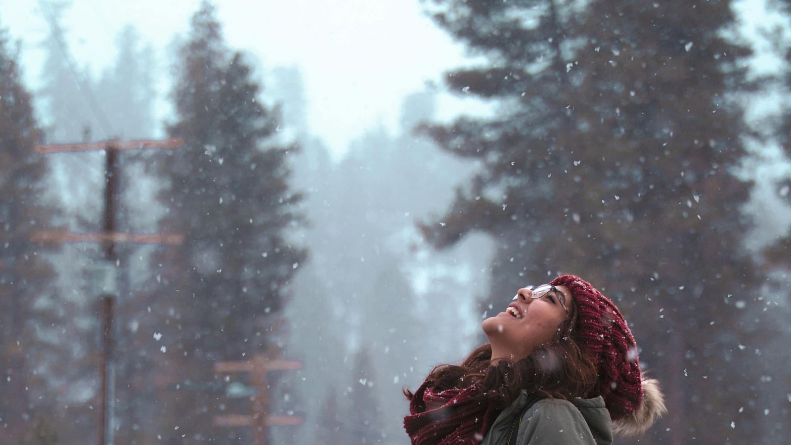 A woman enjoying snow fall.