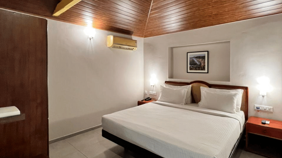 a double bed with side tables and lamps inside one of the rooms - Abad Harmonia, Kovalam