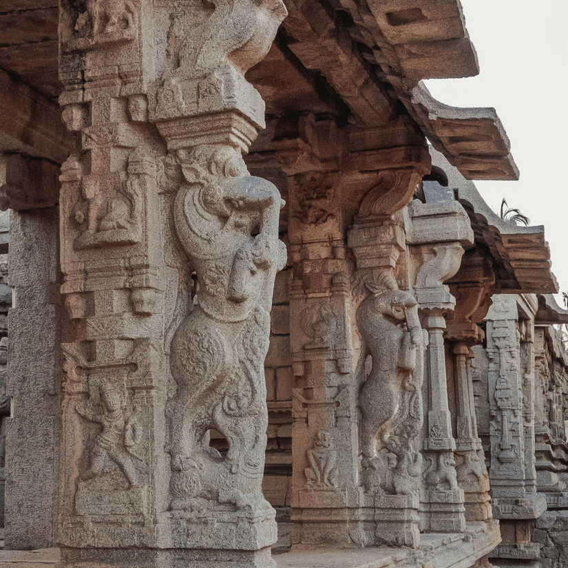 A close-up view of pillars at a historic site, featuring intricate carvings on each column.