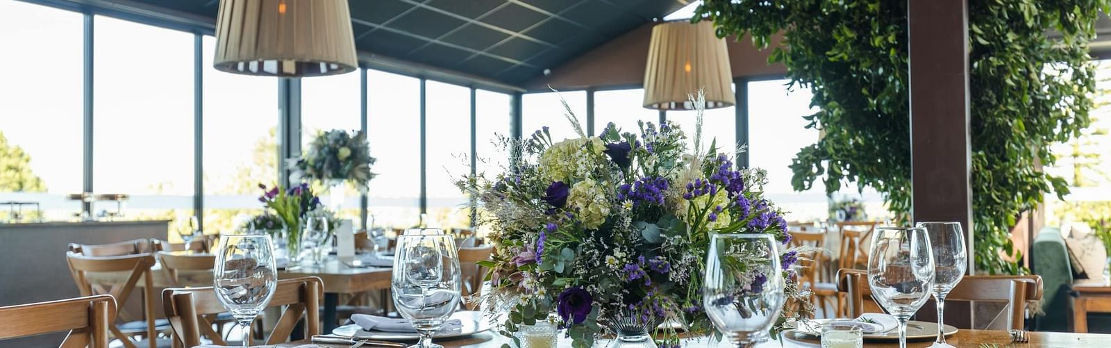 Banquet hall with cutley on the table and lights hamging from the ceiling