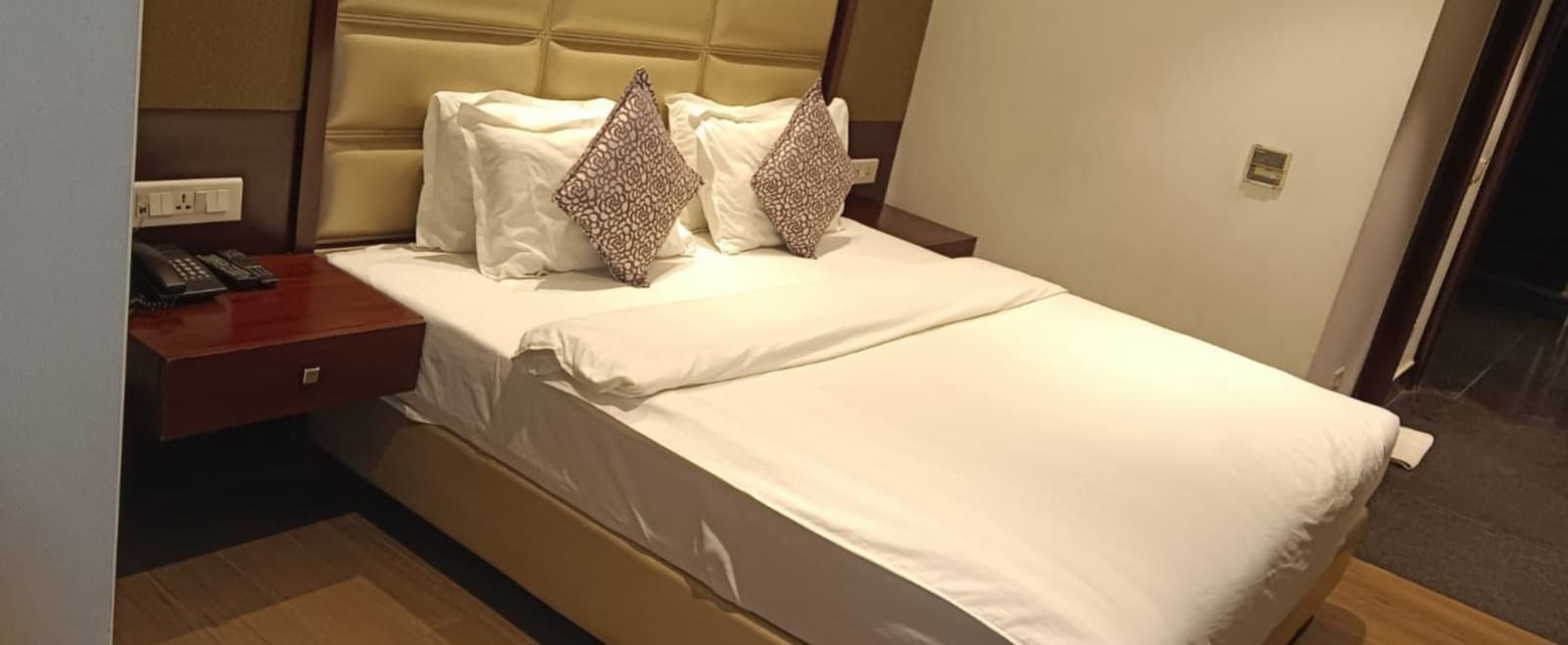 Modern guest room at BluSalzz Select - City Centre, Amritsar with a neatly made double bed and side lamps.
