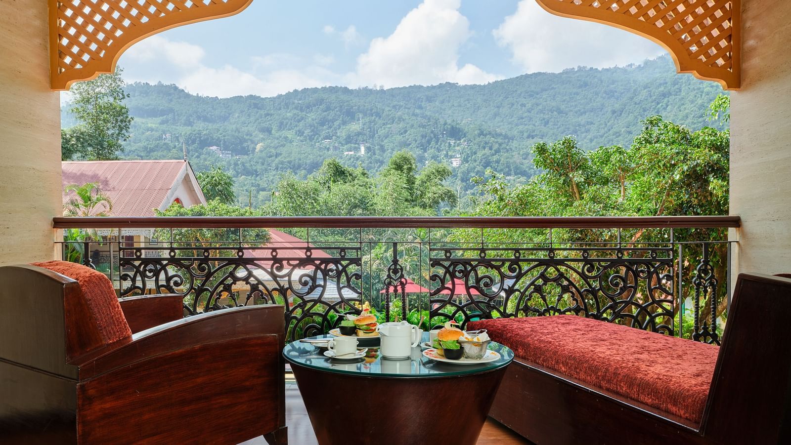 Two sofas with a table in between and a view of hills from the balcony.