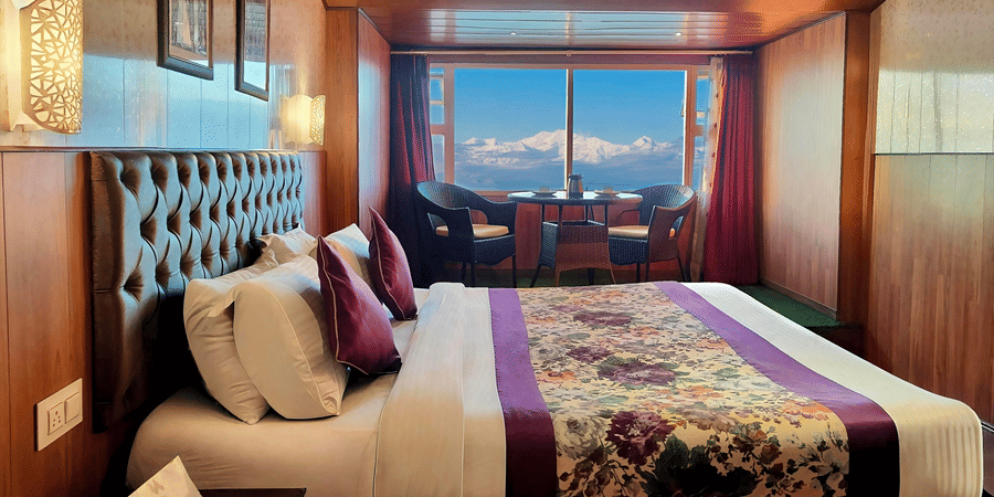 Bedroom with mountain views and warm wooden interiors at Mount Thistle Boutique Hotel, Darjeeling.