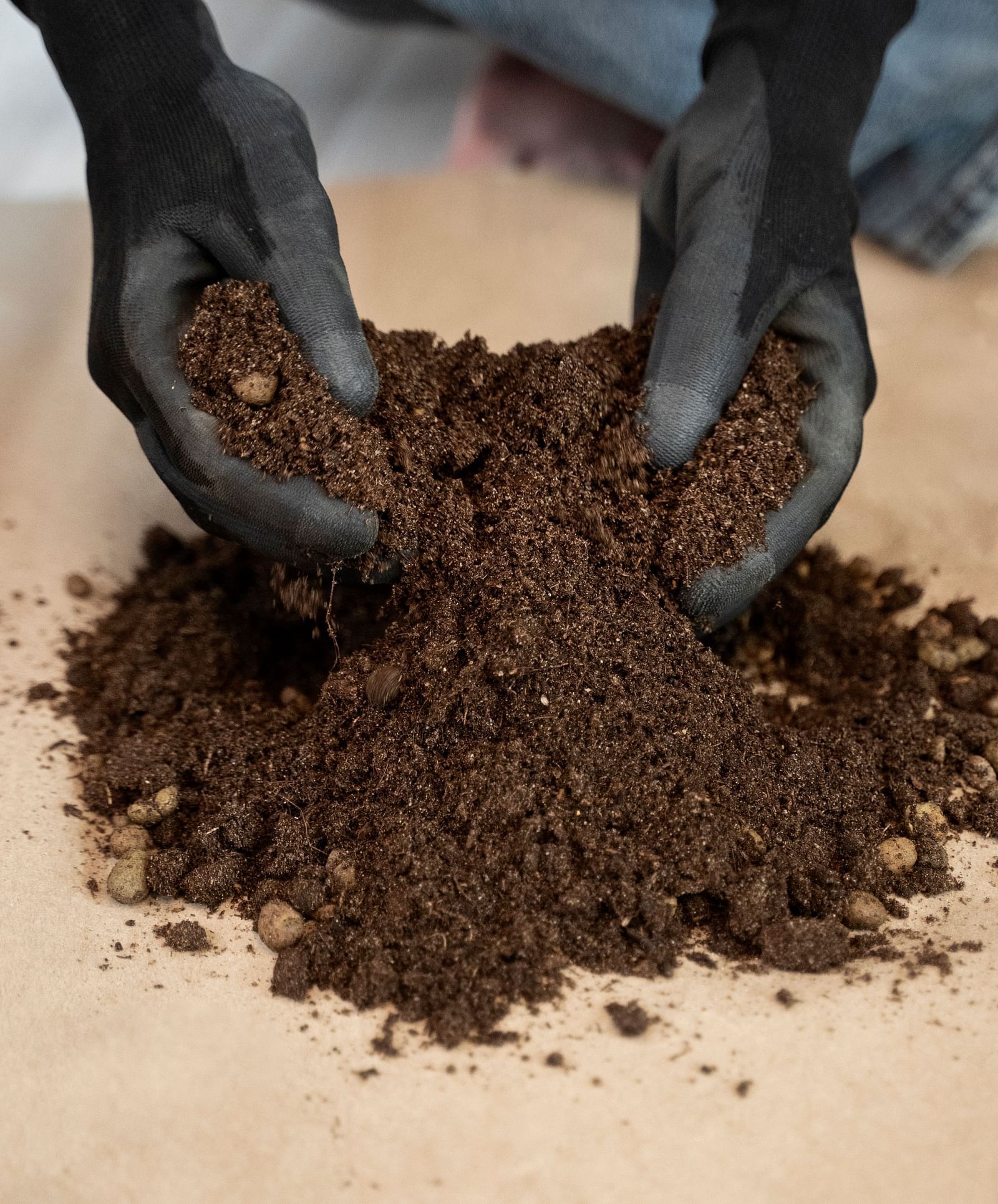 a close-up view two hands holding soil.