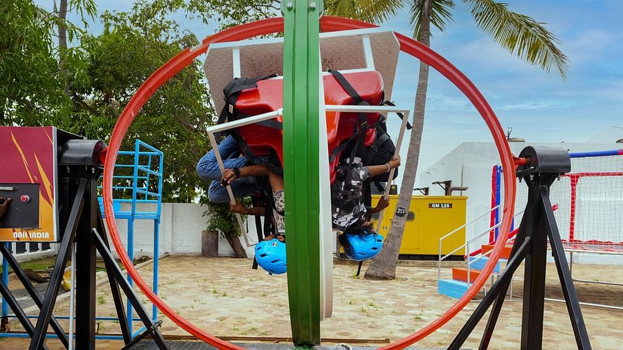 A gyro ride where people are sitting upside upside down in MGM Dizzee World. The ride consist of a round ring attached with seats which makes them spin and rotate in all directions. 