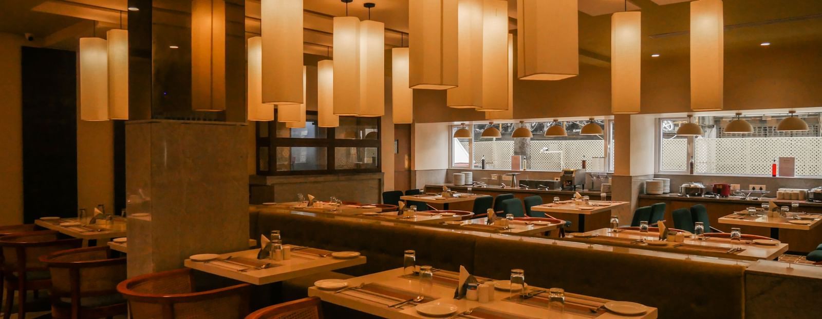 A warm and welcoming restaurant interior with stylish lighting and comfortable dining chairs at Shilton Dee Cee.
