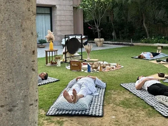 Guests relaxing while yoga in the garden area beside the building at Karma Chalets.