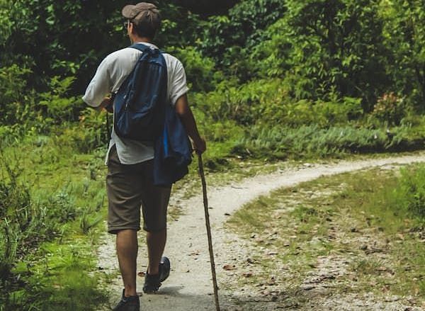 A person walking with a stick on his hand.