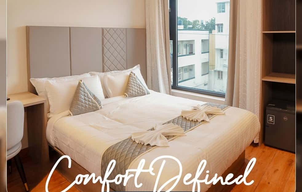 Classic Queen Room with a queen bed and a window view of the neighboring buildings