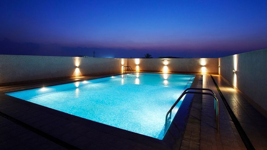 Overview of the swimming pool with lights on on during the night - Hotel Pai Vista, Mysore 