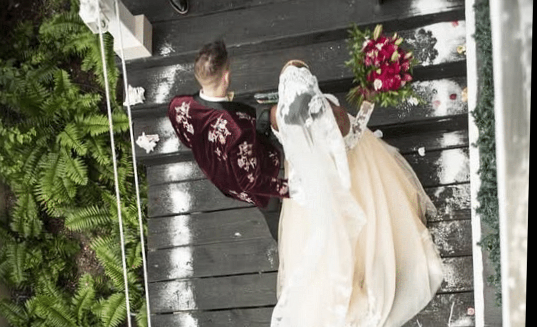 Overhead view of a couple walking on a wooden deck surrounded by greenery | A Stone's Throw Away