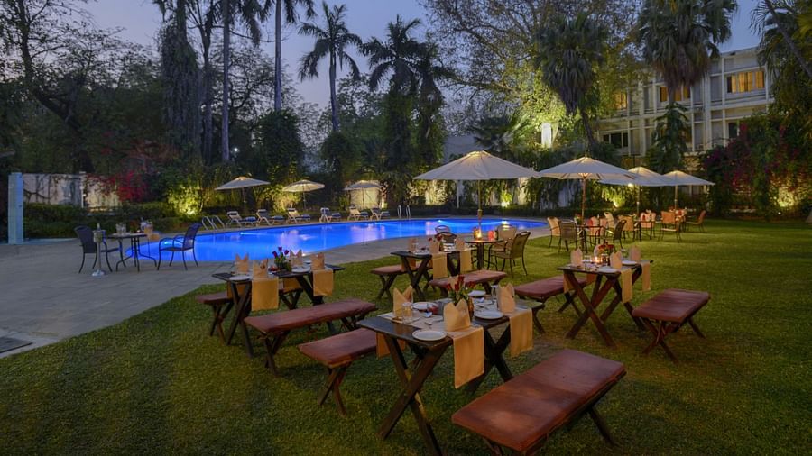 Clarks Varanasi - outdoor dining set up by the pool at nightttime