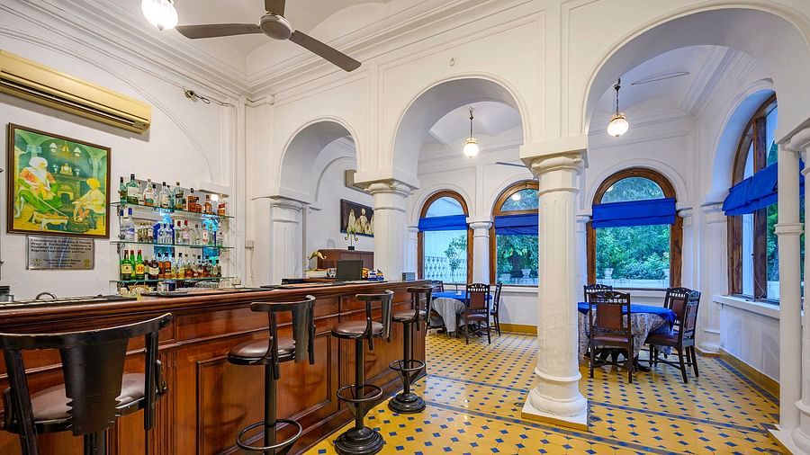 Various bar stools in front of a bar table with drinks in the background - The Baradari Palace