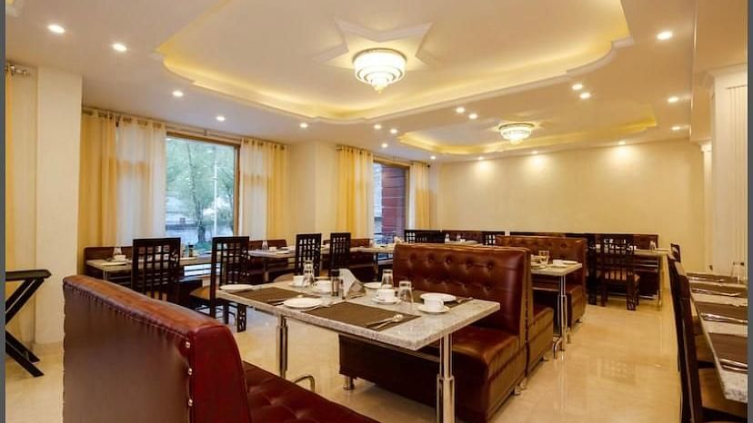A dining area in La Serene Valley Resort in Manali. The dining room is well-lit and dining tables. | DLS La Serene Manali