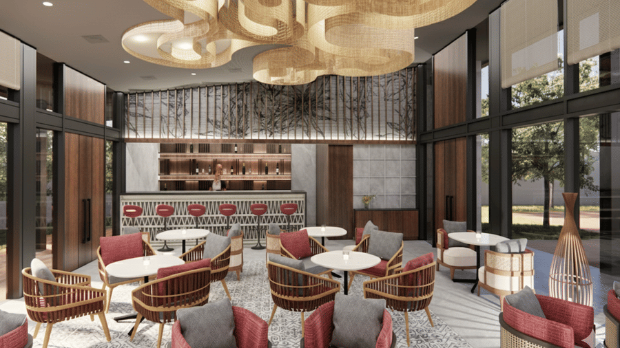Render of a bar area at Vandhara Sarovar Premiere, Patkote, with patterned armchairs, small round tables, and large decorative circular ceiling fixtures.