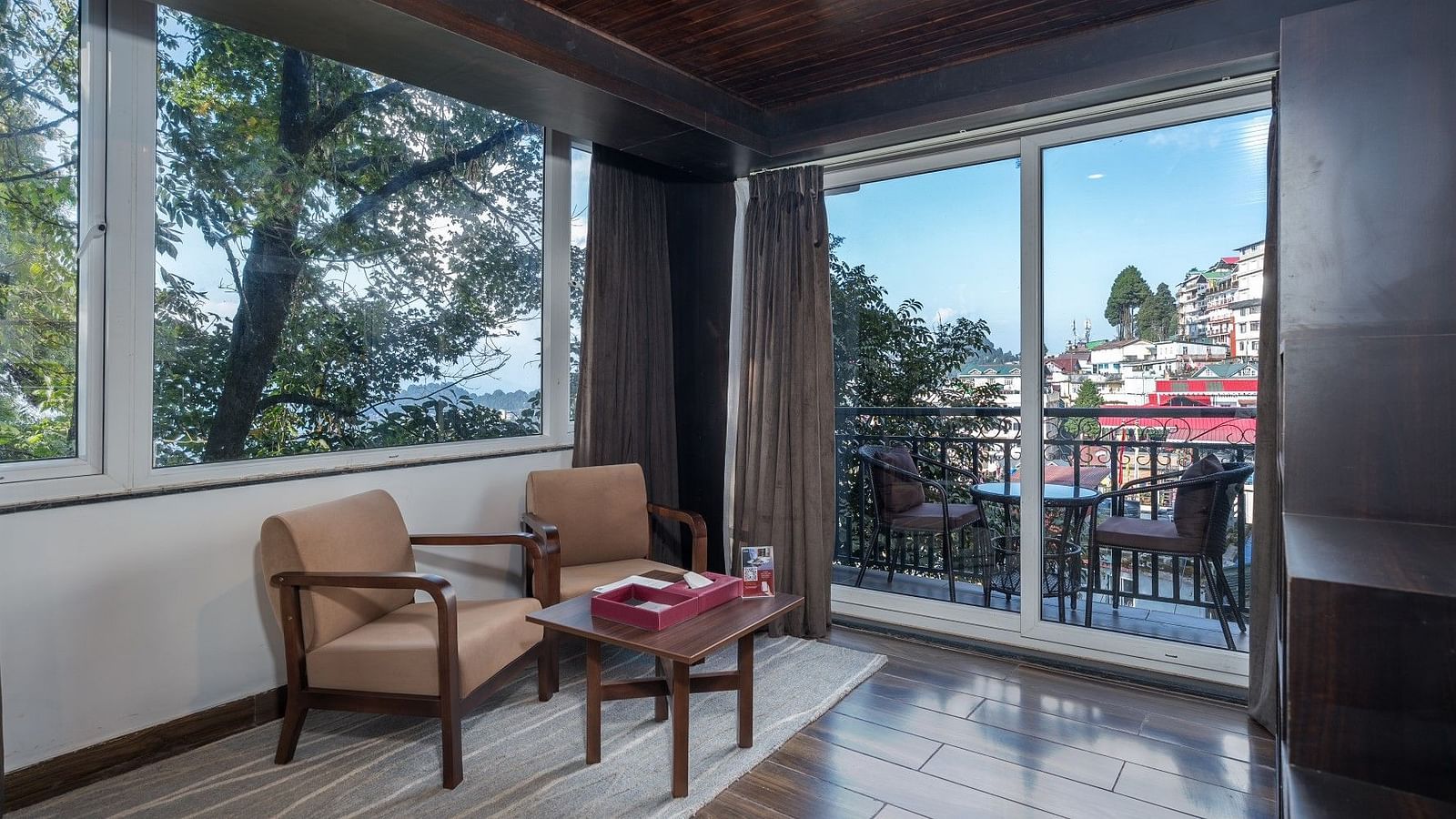Image of the balcony from the room along with two chairs and the table.