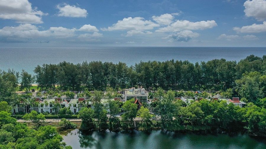 image featuring the resort nestled amidst green trees and a vast blue ocean in the background