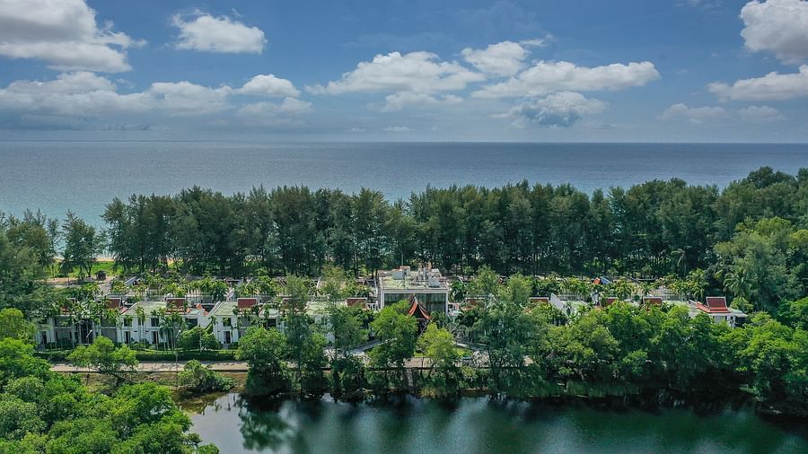 image featuring the resort nestled amidst green trees and a vast blue ocean in the background